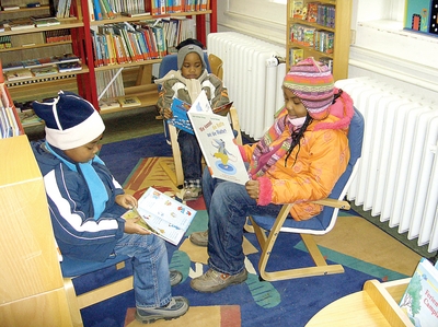 3 Kinder beim Lesen in der Katholischen Bücherei.
